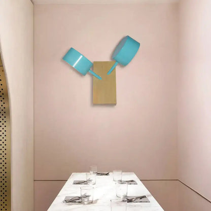 White ceramic drum sconce by Decorbites; wall-mounted dual teal lamp fixture on wooden backer on Tampa Home & Garden Store