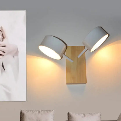 White dual drum wood wall sconce with wood backplate and two adjustable shades, warm light on Tampa Home & Garden Store