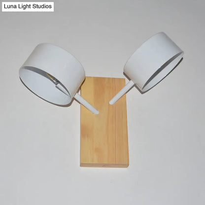 White dual-drum wood wall sconce with natural wood backplate and white shade on angled arms on Tampa Home & Garden Store