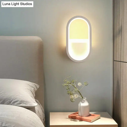 Decorbites White Elliptical LED Wall Sconce mounted on bedroom wall beside nightstand on Tampa Home & Garden Store