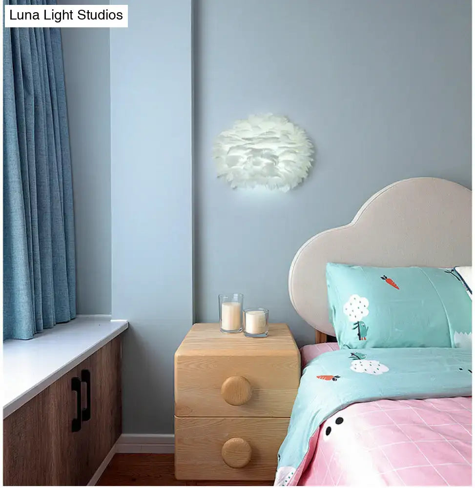 White Feather Wall Lamp with feather shade mounted on pale blue wall above a wooden nightstand on Tampa Home & Garden Store