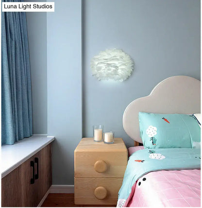 White Feather Wall Lamp with feather shade mounted on pale blue wall above a wooden nightstand on Tampa Home & Garden Store