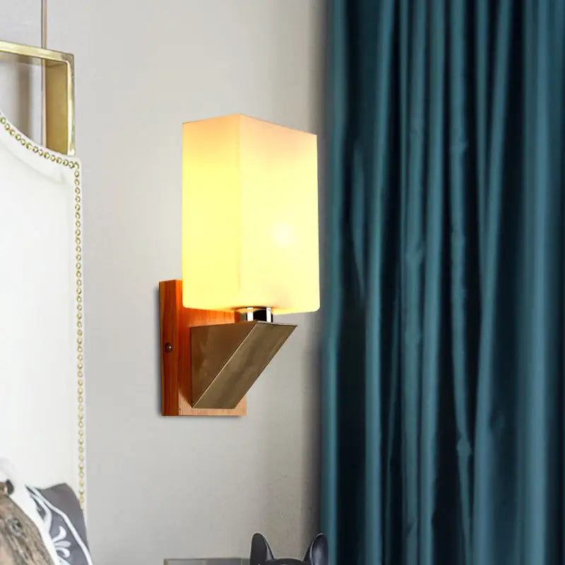 White glass wall lamp with warm glow, wooden backplate and brass angled mount by Decorbites on Tampa Home & Garden Store