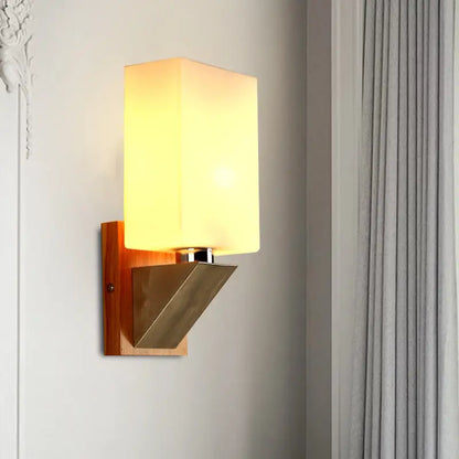 White glass wall lamp with warm glow, wooden backplate and metal angular mount on Tampa Home & Garden Store