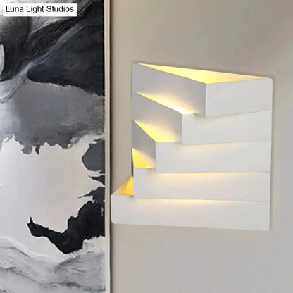 Modern white geometric wall sconce with stepped blocks and warm glow on Tampa Home & Garden Store