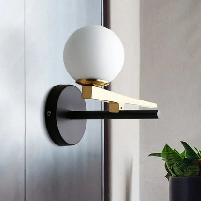 Gold Glass Sphere Wall Light sconce with frosted globe, gold arm, black backplate by Decorbites on Tampa Home & Garden Store