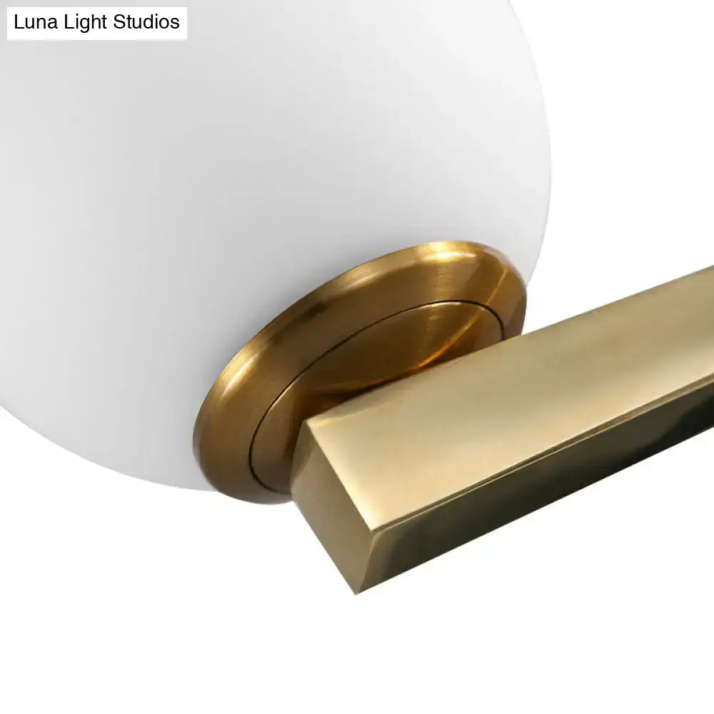 White glass sphere wall light with brass mount and rectangular gold-tone arm Decorbites on Tampa Home & Garden Store