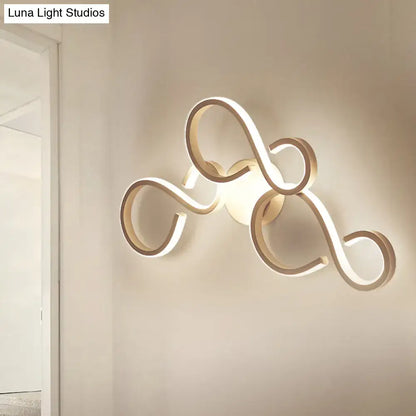 White infinity spiral wall light with looping LED tubes, wall-mounted Decorbites lamp with Luna Light Studios watermark on Tampa Home & Garden Store