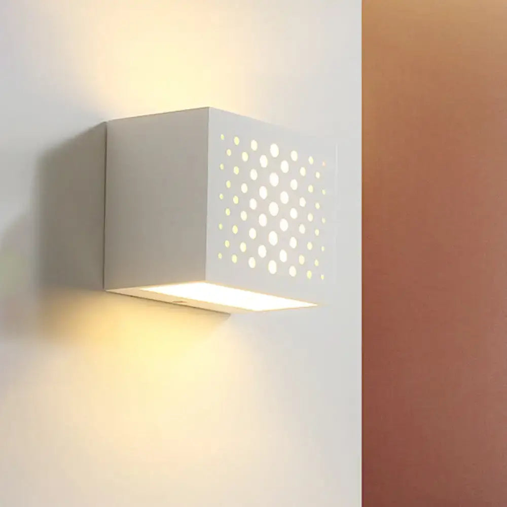White gypsum cube wall-mounted sconce with laser-cut perforated front emitting warm light on Tampa Home & Garden Store