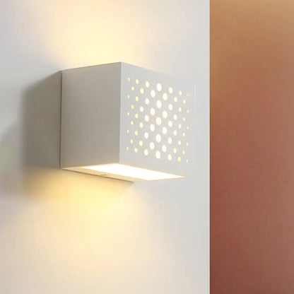 White gypsum cube wall-mounted sconce with laser-cut perforated front emitting warm light on Tampa Home & Garden Store