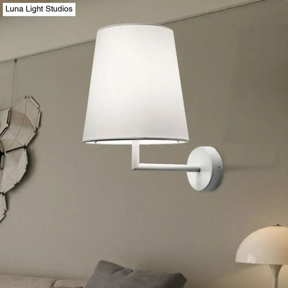 White fabric cone LED wall sconce with slim metal arm mounted on neutral wall on Tampa Home & Garden Store