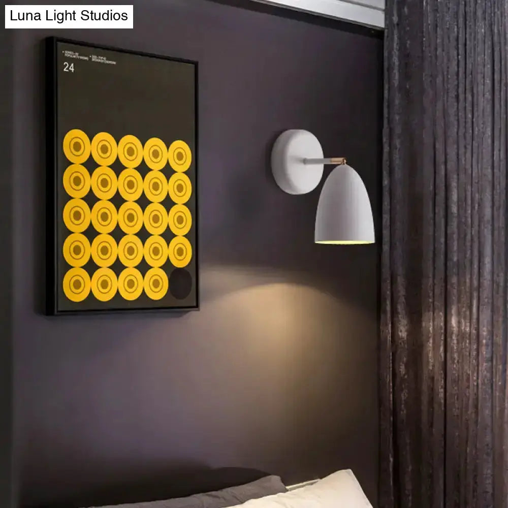 Modern white metal wall lamp with cone shade mounted on a dark wall beside circular art on Tampa Home & Garden Store