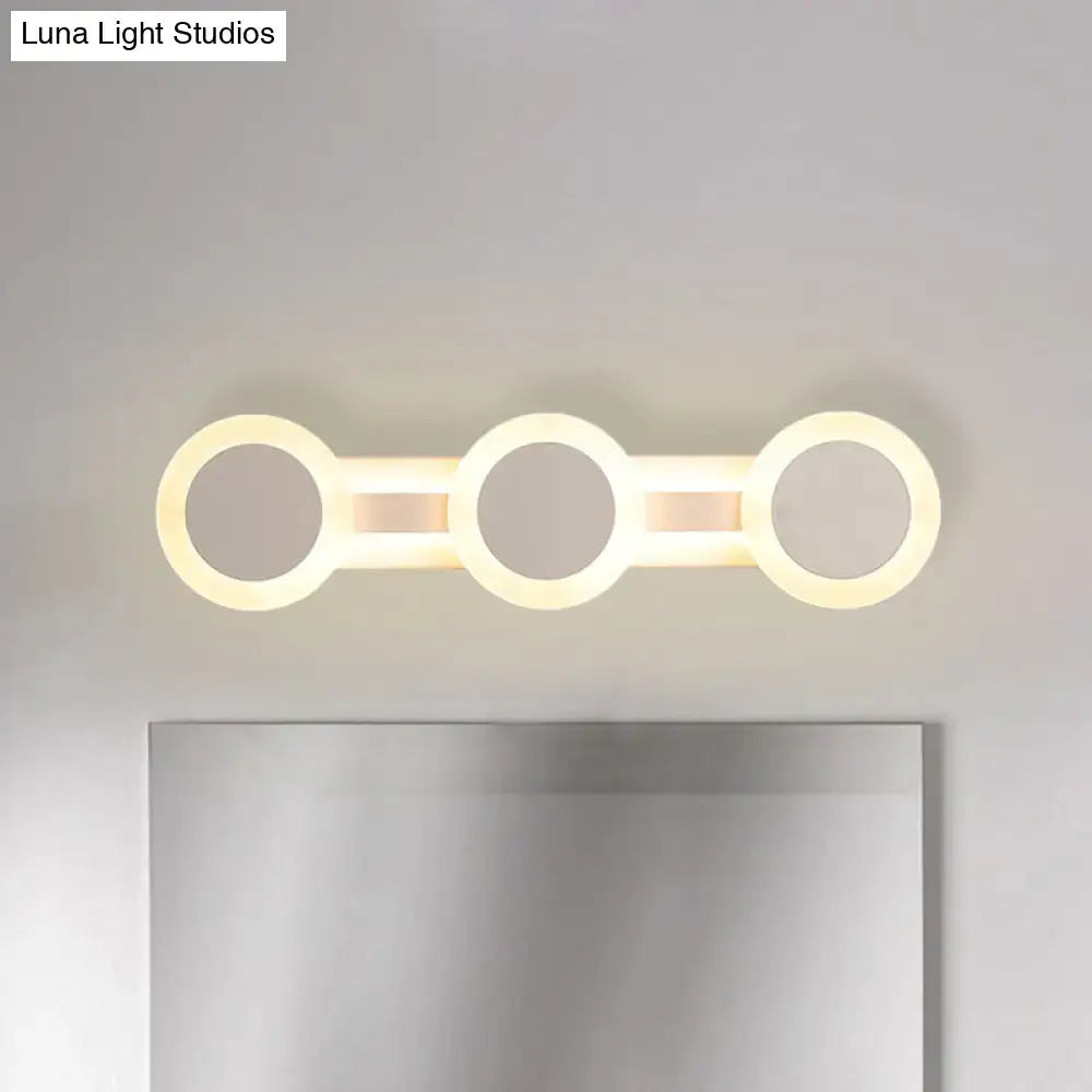 White vanity wall sconce with three connected circular LED rings; Decorbites, Luna Light Studios on Tampa Home & Garden Store