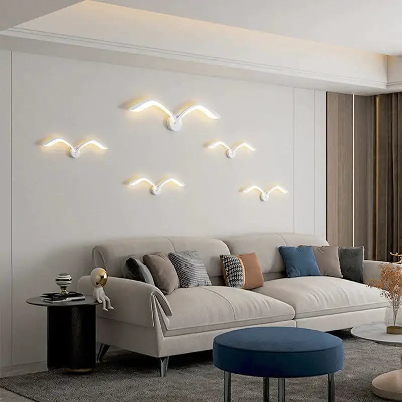 White Nordic Wing Sconce wall light with winged LED accents mounted on a wall above a sofa on Tampa Home & Garden Store
