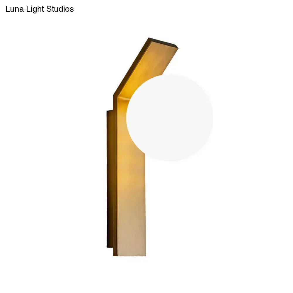 Milk Glass Wall Sconce with brass-gold backplate and angled arm, round white glass shade on Tampa Home & Garden Store