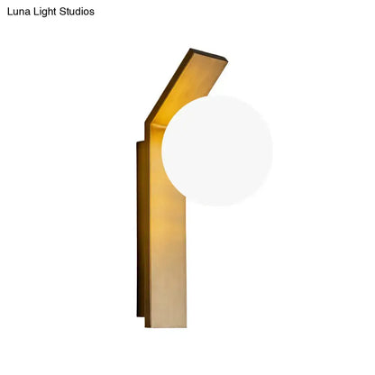 Milk Glass Wall Sconce with brass-gold backplate and angled arm, round white glass shade on Tampa Home & Garden Store