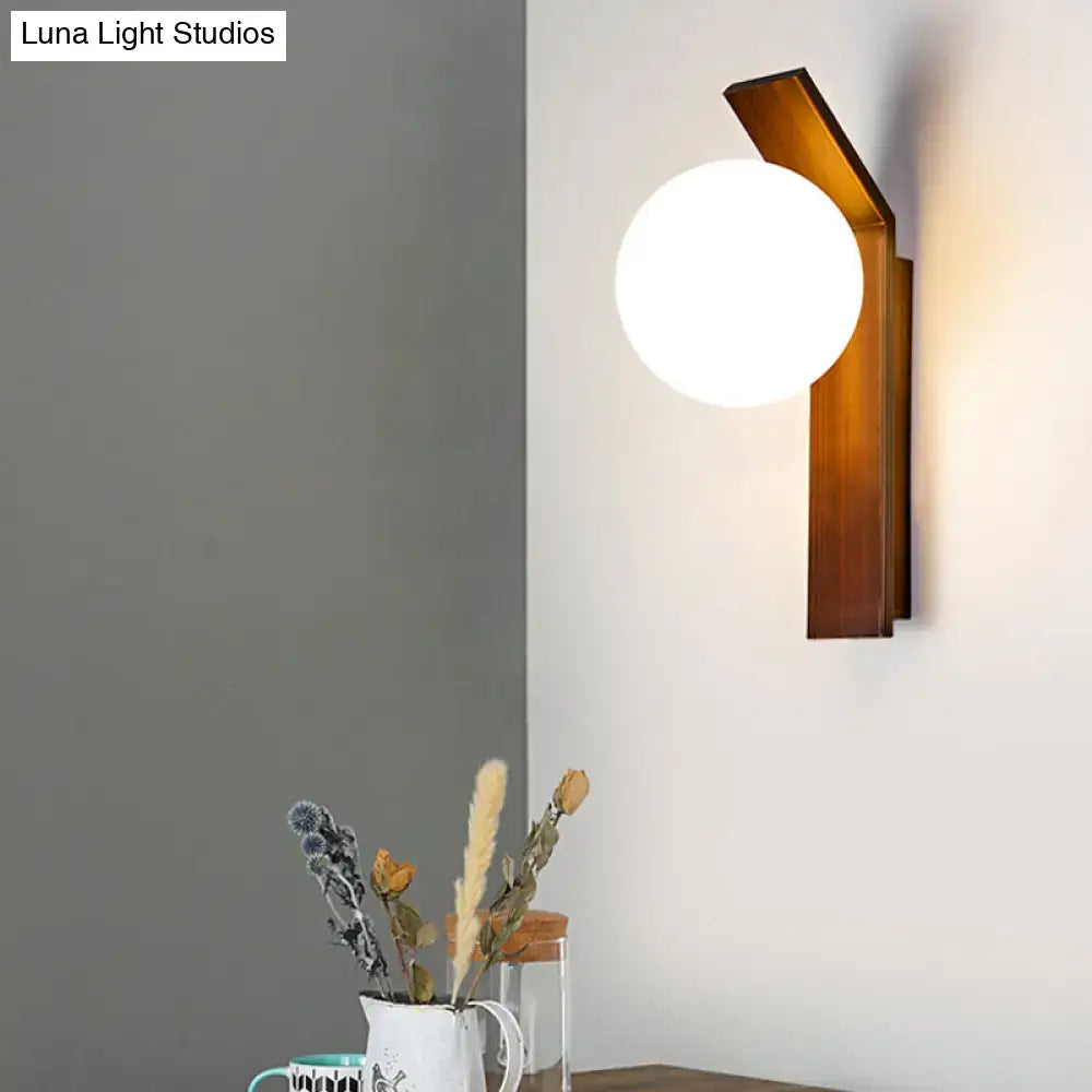 Milk glass wall sconce with brown wooden backplate and round white globe on Tampa Home & Garden Store