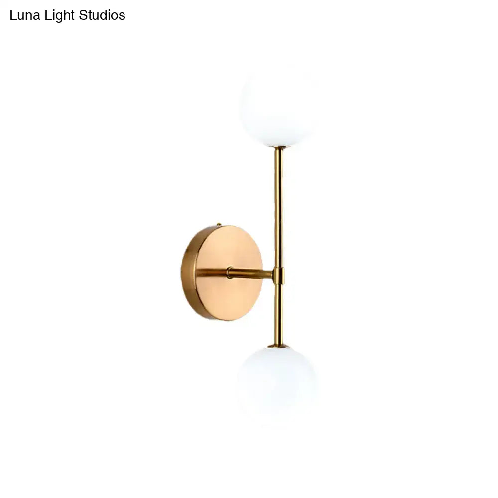 Gold double globe wall sconce with brass finish and two white glass globes by Decorbites on Tampa Home & Garden Store