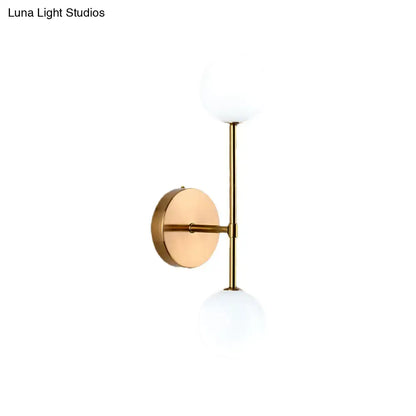 Gold double globe wall sconce with brass finish and two white glass globes by Decorbites on Tampa Home & Garden Store