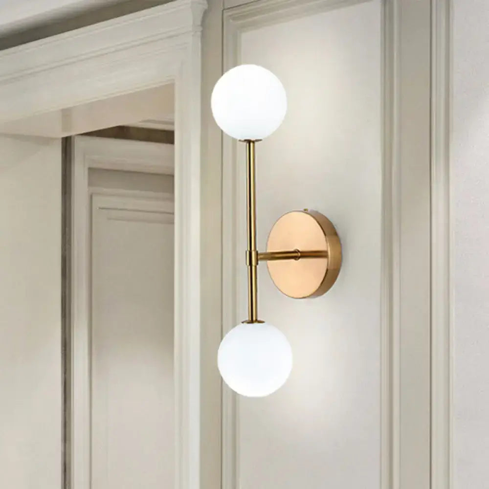 Gold double globe sconce in brass by Decorbites with two frosted glass globes on a wall mount on Tampa Home & Garden Store