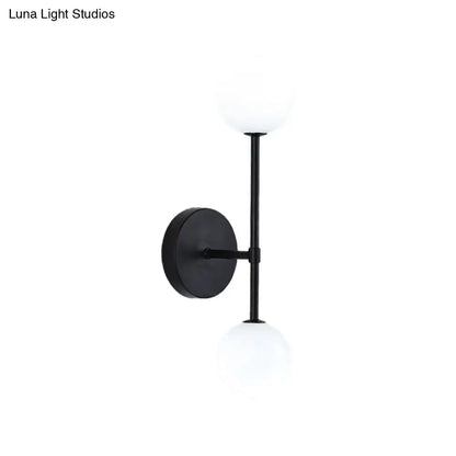 Black double-globe wall sconce with frosted glass globes and circular backplate on Tampa Home & Garden Store