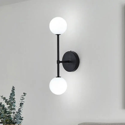 Double Globe Sconce by Decorbites, black metal wall mount with two white glass globes on Tampa Home & Garden Store
