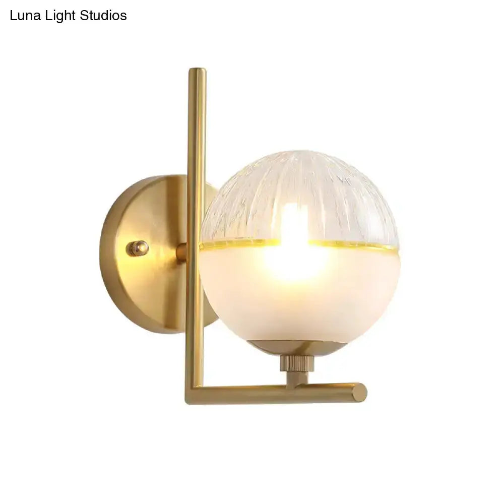 Decorbites modernist brass wall sconce with half frosted globe shade and round backplate on Tampa Home & Garden Store