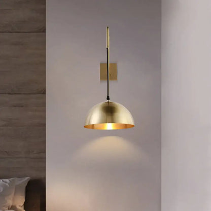 Brass dome wall light by Decorbites with black cord and warm glow on Tampa Home & Garden Store