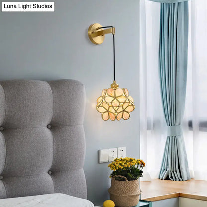 Brass Floral Glass Sconce by Decorbites with gold petal shade beside a gray headboard on Tampa Home & Garden Store