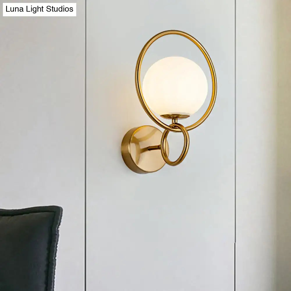 Gold White Glass Sconce with circular gold ring and frosted white glass globe mounted on wall on Tampa Home & Garden Store