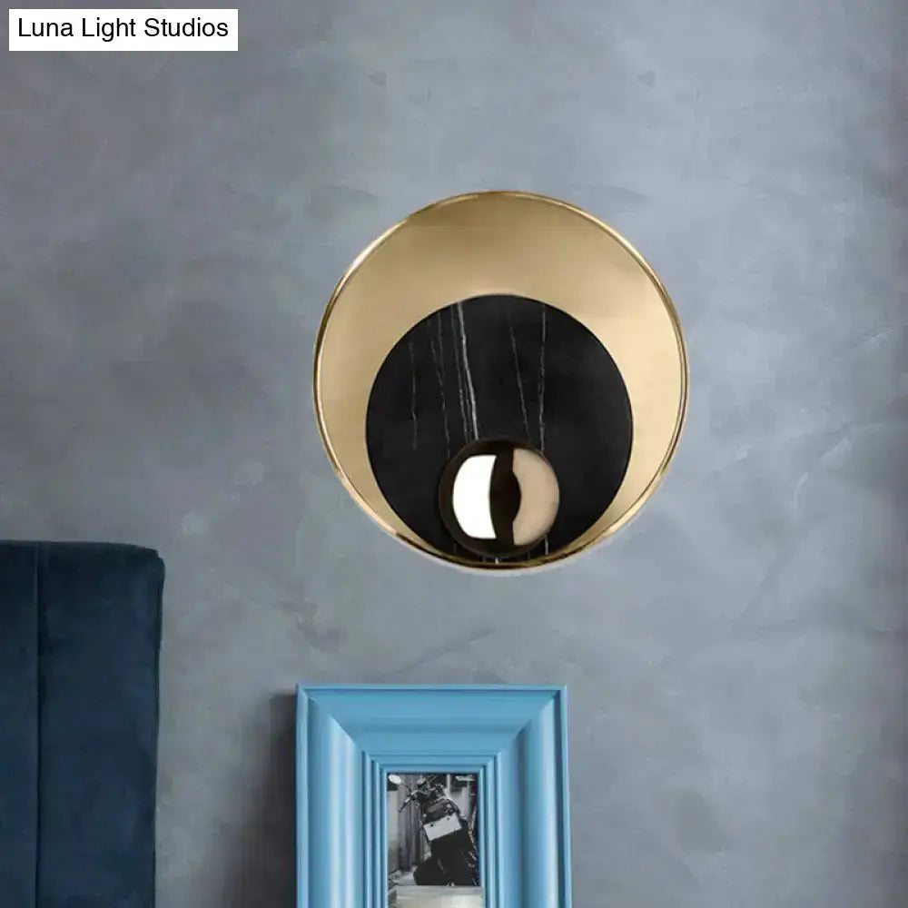 Modernist LED wall sconce with gold frame and black inner disk blue picture frame beneath on Tampa Home & Garden Store