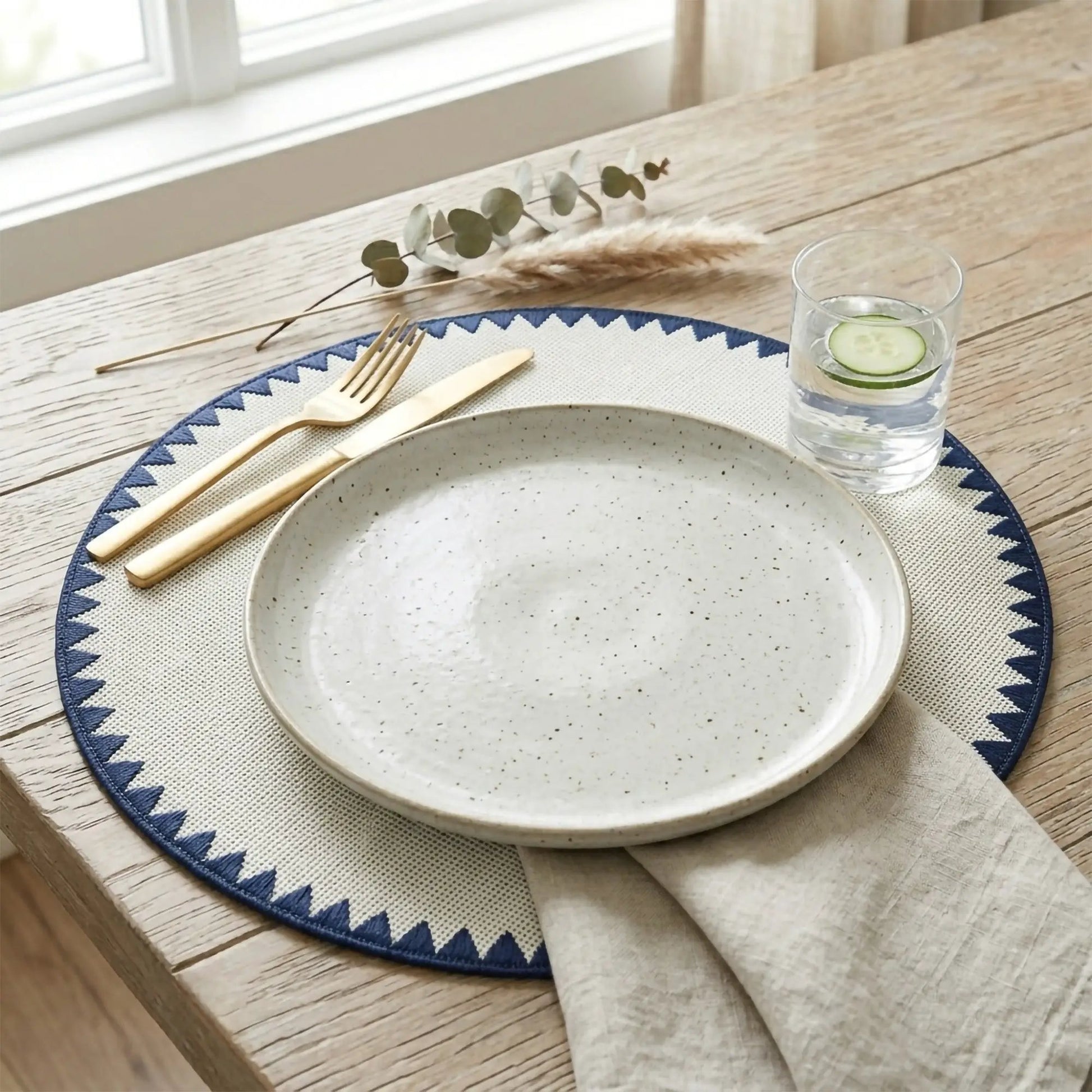 Montana placemat with bold geometric blue trim on a beige speckled plate setting on Tampa Home & Garden Store