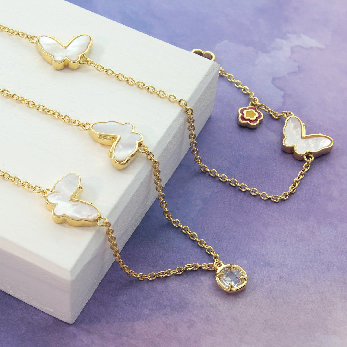 Mariposa long necklace in gold-tone with butterfly charms, a flower charm, and a gem pendant on Tampa Home & Garden Store