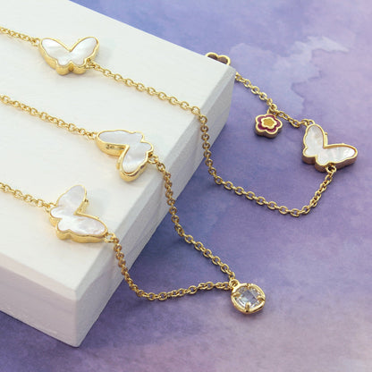 Mariposa long necklace in gold-tone with butterfly charms, a flower charm, and a gem pendant on Tampa Home & Garden Store