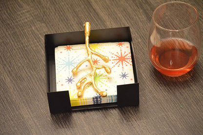 Vibhsa napkin holder with gold olive bud, colorful starburst napkin in display box on Tampa Home & Garden Store
