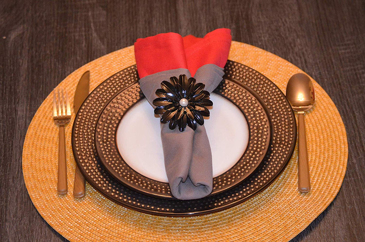 Vibhsa black floral napkin rings with pearl centers, set of 4, on napkin over plate on Tampa Home & Garden Store