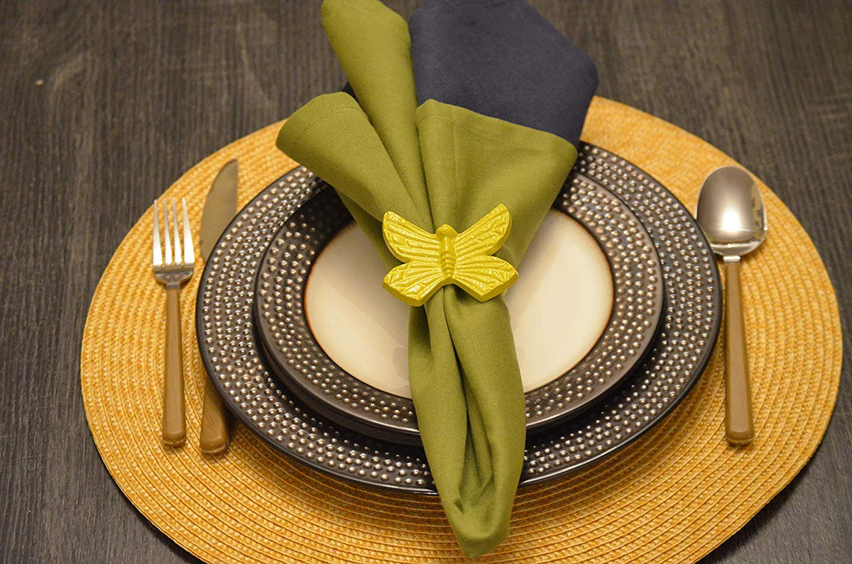 Vibhsa Yellow Butterfly Napkin Rings, handcrafted aluminum, set of 4 around a green napkin on Tampa Home & Garden Store