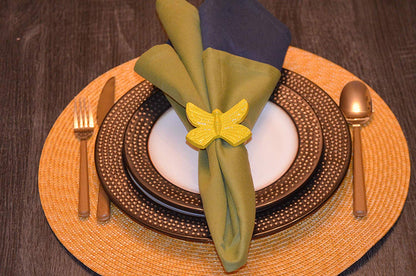 Vibhsa yellow butterfly napkin ring on olive green folded napkin with brown beaded charger plate on Tampa Home & Garden Store