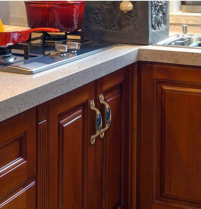 Navy blue ceramic cabinet handles by Stevvex with brass-tone antique pulls on wood cabinets on Tampa Home & Garden Store