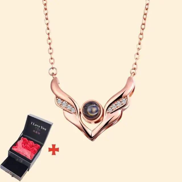 Rose-gold wing pendant necklace with dark gem on chain, paired with red roses gift box on Tampa Home & Garden Store