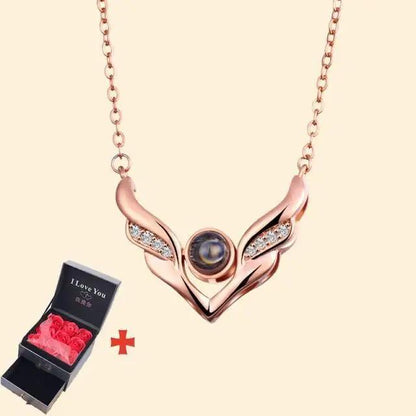 Rose-gold wing pendant necklace with dark gem on chain, paired with red roses gift box on Tampa Home & Garden Store