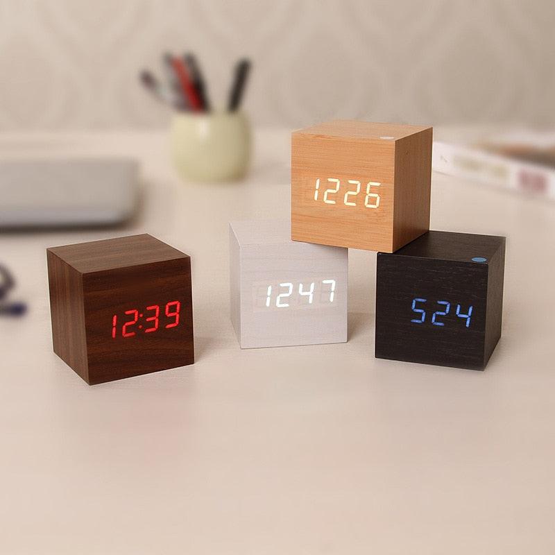 Four wooden cube LED alarm clocks with digital displays in brown, white, black and natural wood on Tampa Home & Garden Store