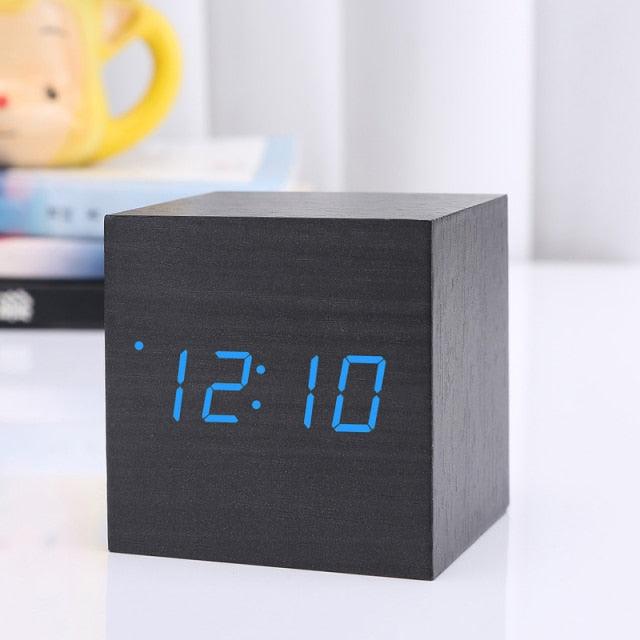 Wooden cube alarm clock with blue LED digital time display showing 12:10 on Tampa Home & Garden Store