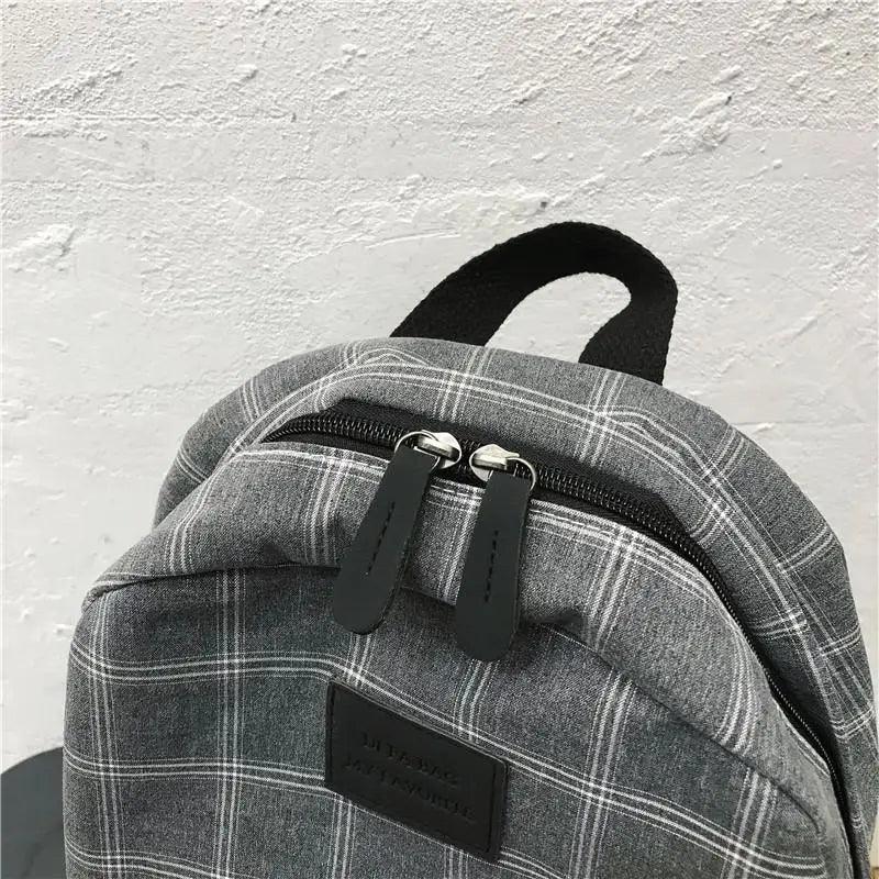 Grey plaid school backpack with double zippers, black pulls, top handle, Stevvex logo patch on Tampa Home & Garden Store