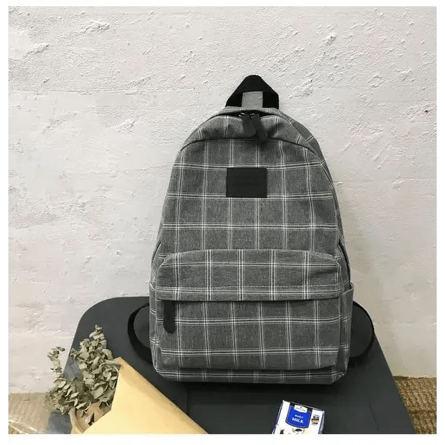 Stevvex gray plaid school backpack with front zip pocket and black patch on table on Tampa Home & Garden Store