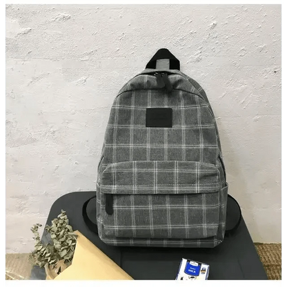 Stevvex gray plaid school backpack with front zip pocket and black patch on table on Tampa Home & Garden Store