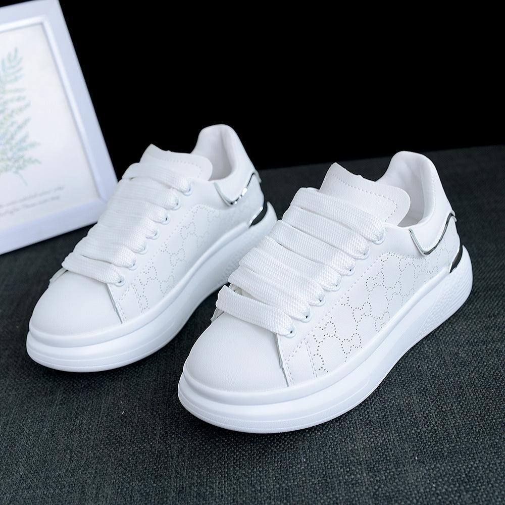 Pair of white women's lace-up sneakers with thick soles and stitched side pattern on Tampa Home & Garden Store