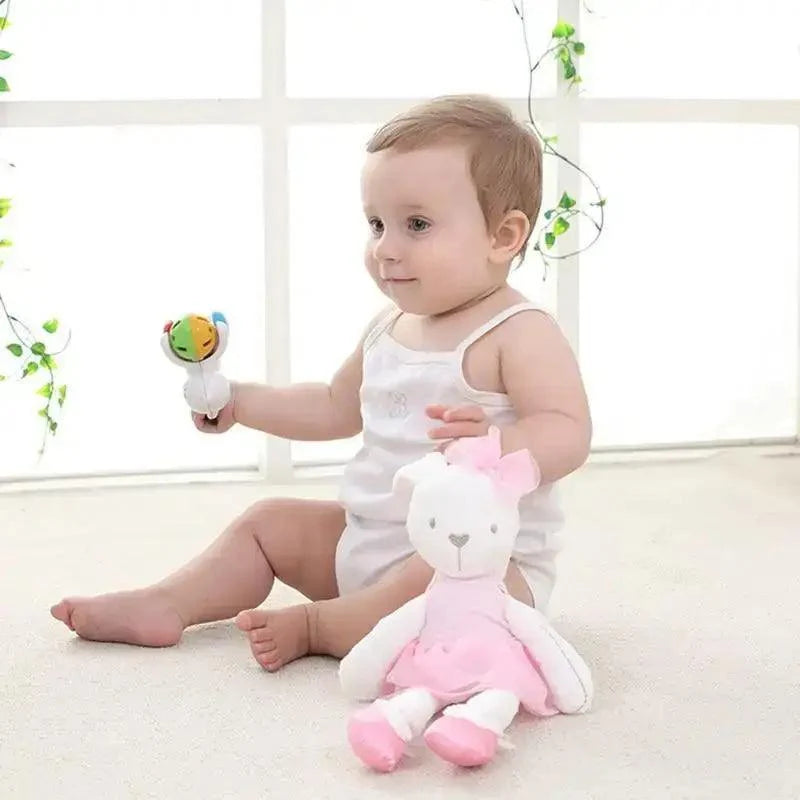 Stuffed rabbit plush toy in white fur with pink dress and bow, baby plays with colorful rattle on Tampa Home & Garden Store