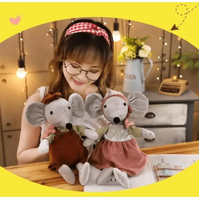 Two soft plush mice, gray with pink dress and brown outfit, held by smiling girl on Tampa Home & Garden Store