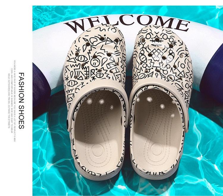 Stevvex men's beige slip-on sandals with black doodle pattern, arch support, pair on pool backdrop on Tampa Home & Garden Store